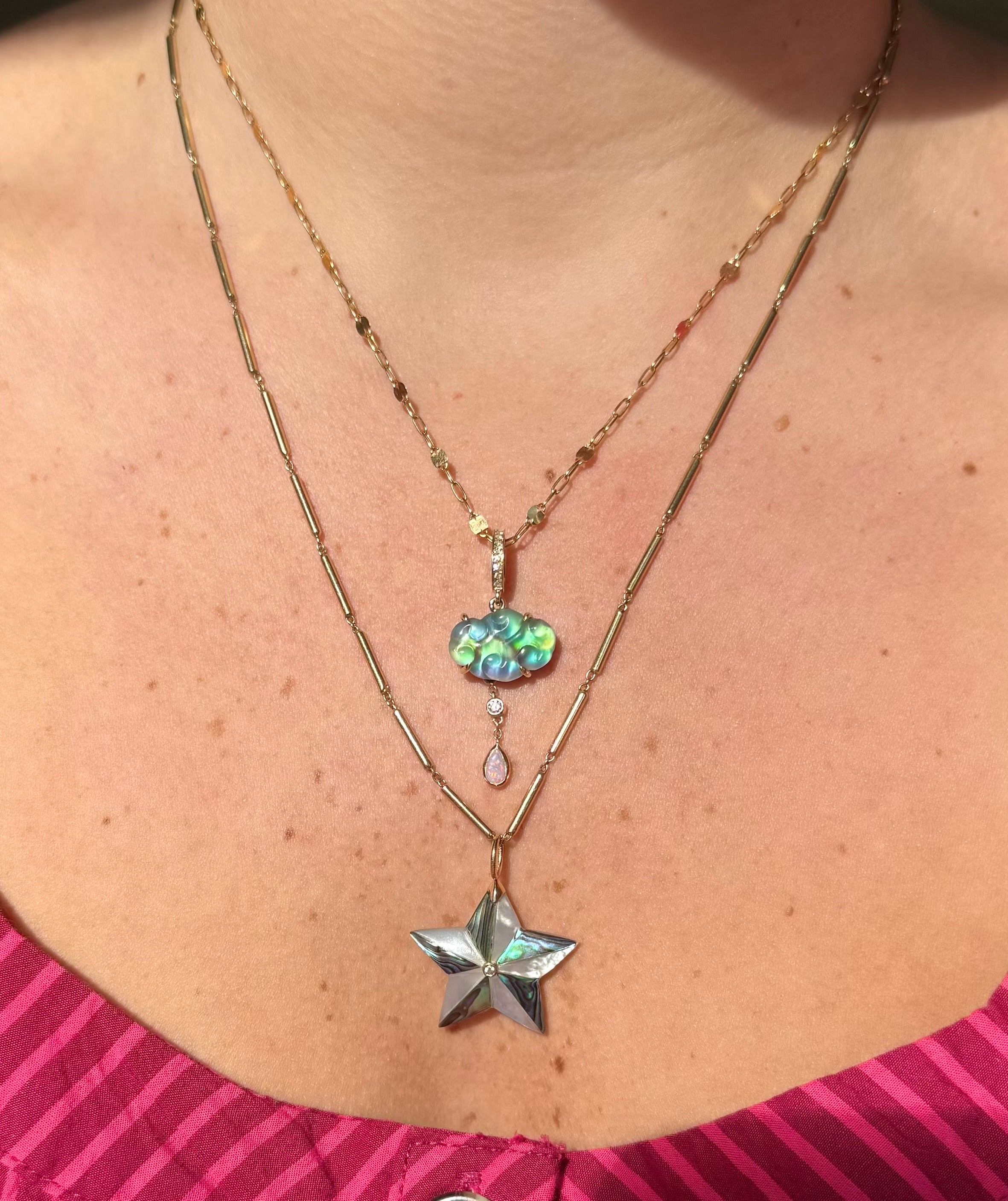 Necklace with star and cloud-shaped pendant worn by a person