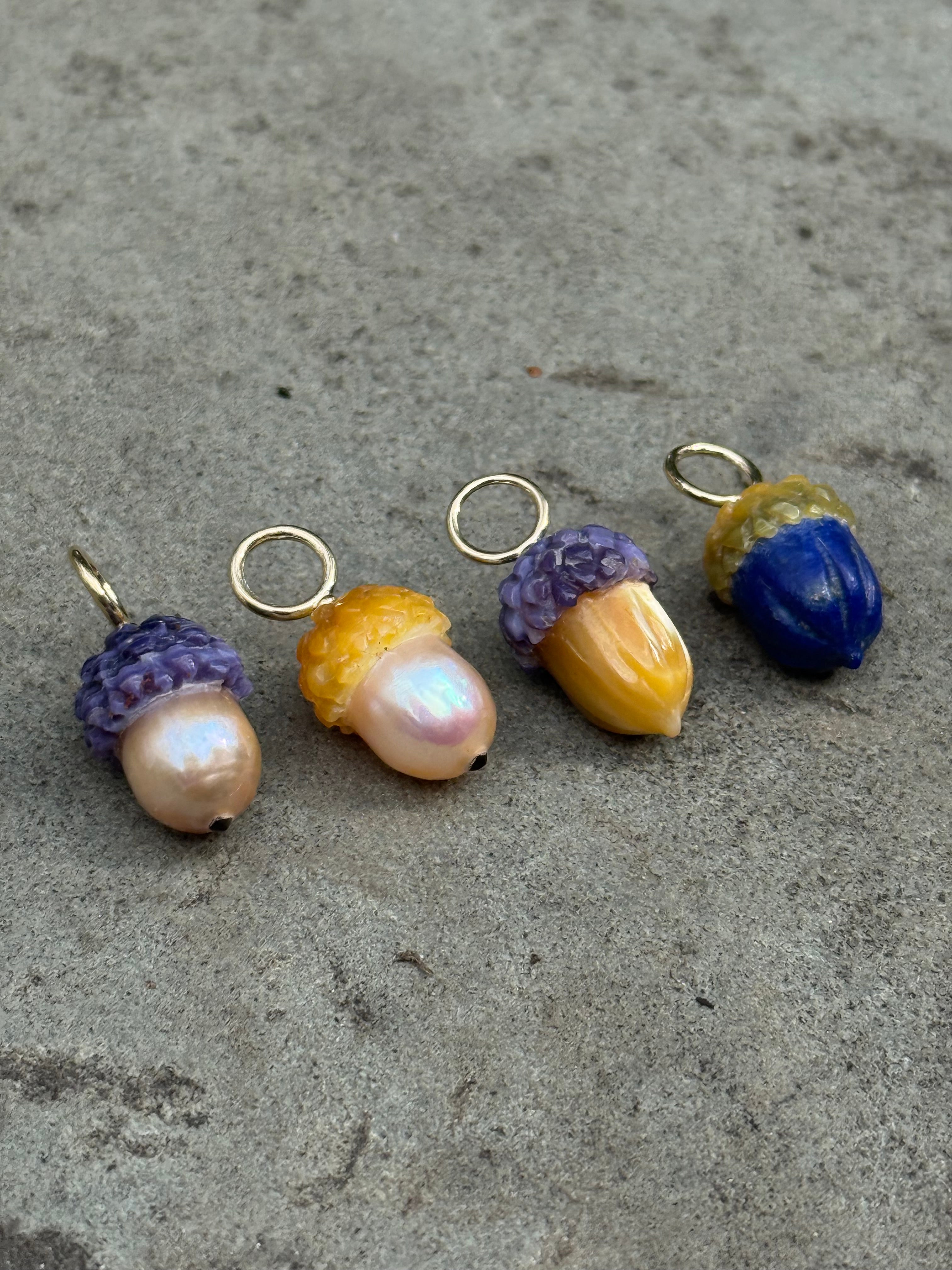 Colorful acorn-shaped charms on a gray surface