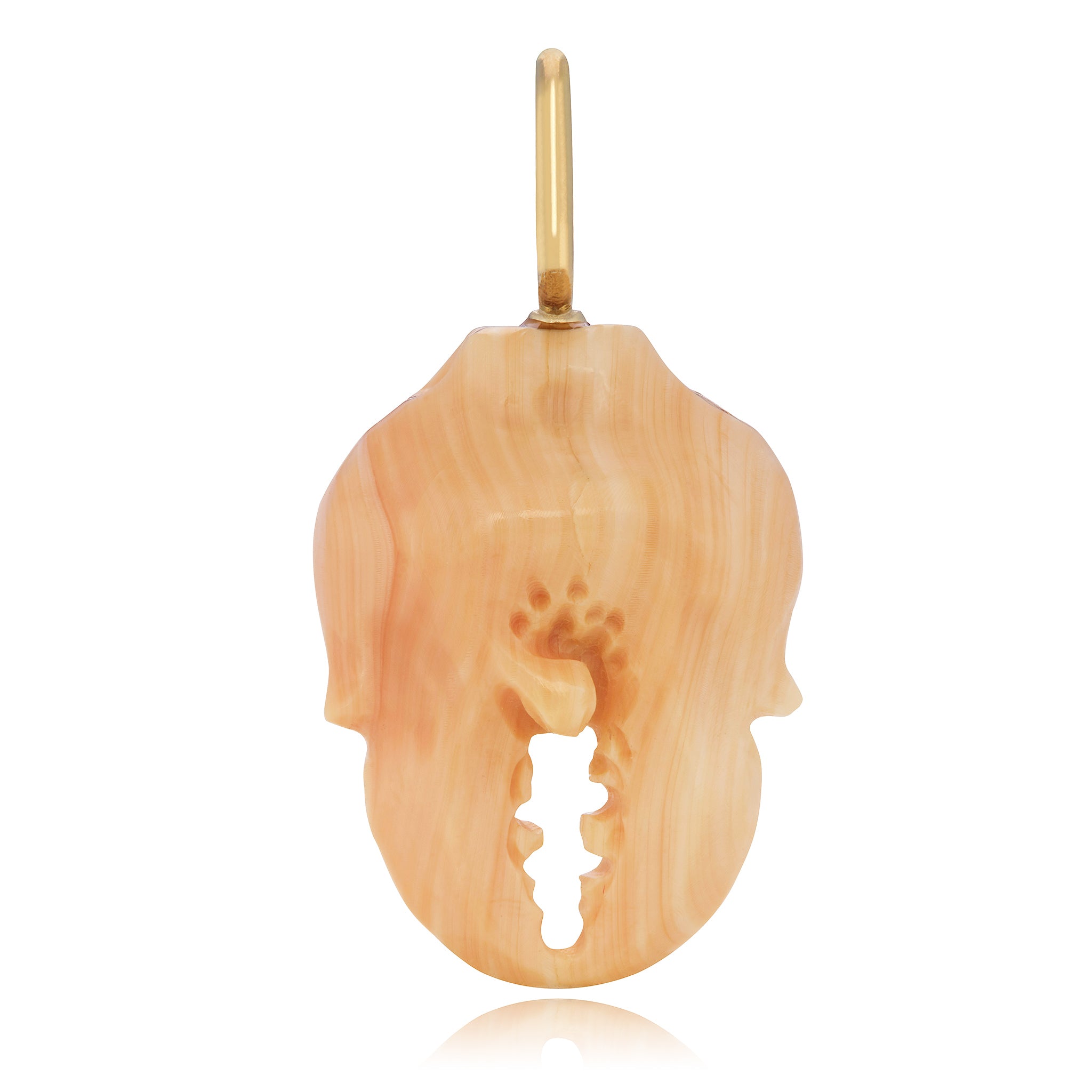 A carved apricot conch shell crab claw with a 14K yellow gold bail. Designed by Maura Green