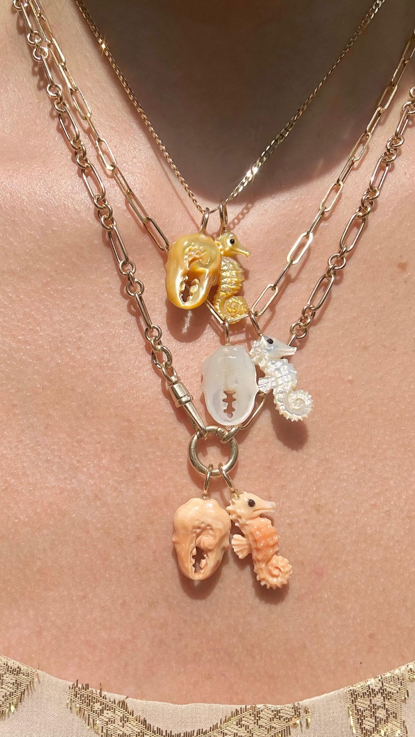 Apricot conch shell crab claw charm with 14K gold worn on model designed by Maura Green