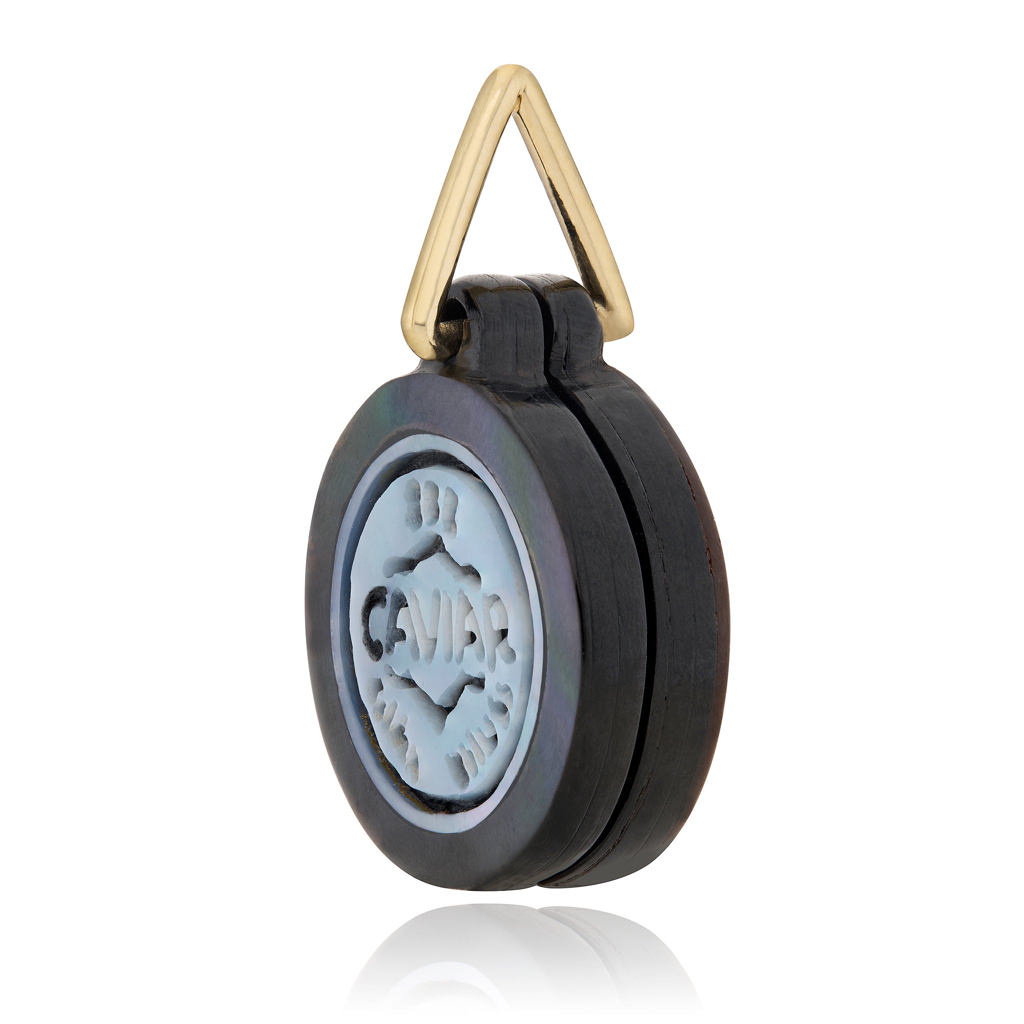 A round black caviar capsule with a light center seal engraved with 'CAVIAR', attached to a gold triangular ring, shown on a white background designed by Maura Green Jewelry