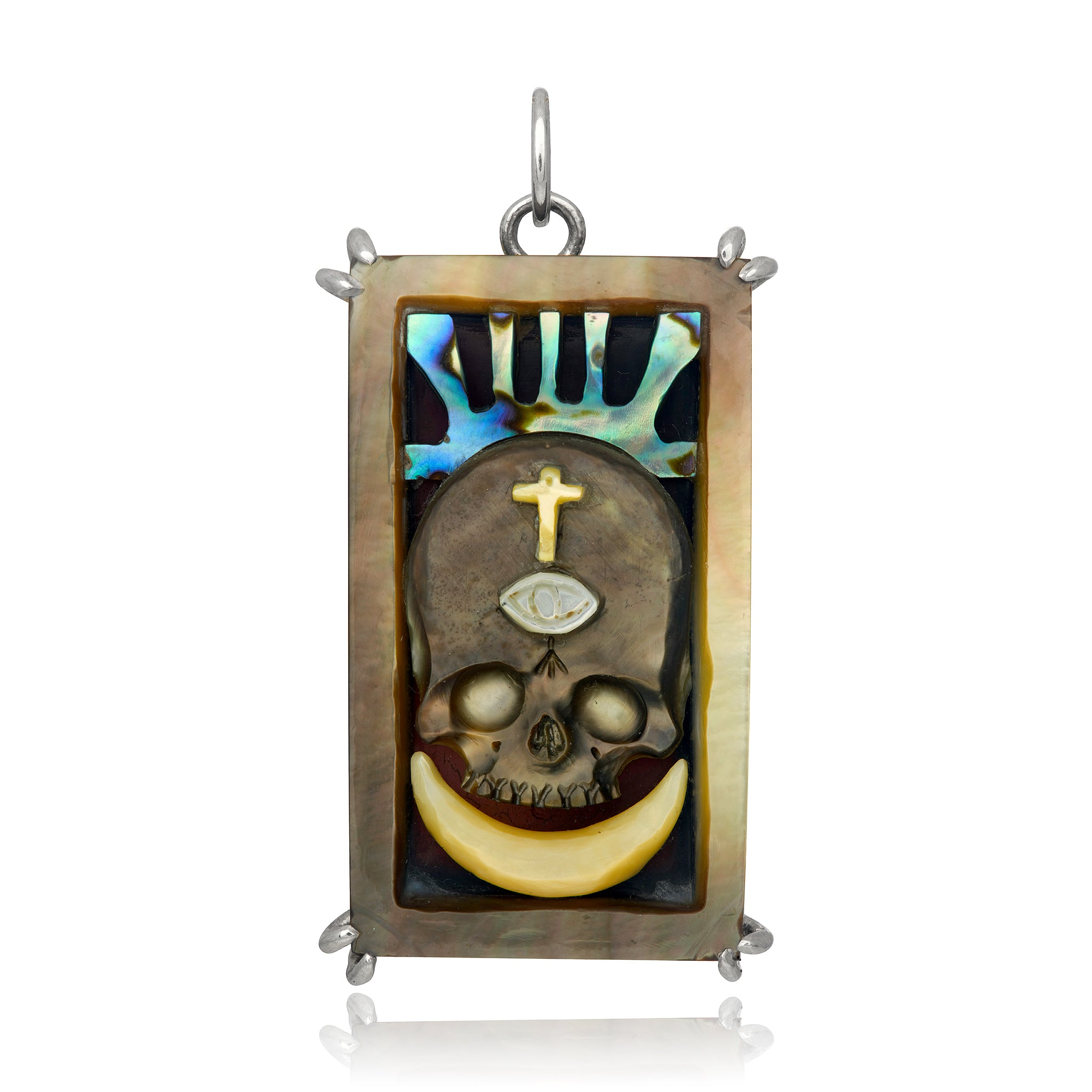 A rectangular charm carved from brown and blue shell,  featuring a skull and crescent moon, representing the Death Tarot Card, set in sterling silver against a white background. Designed by Maura Green