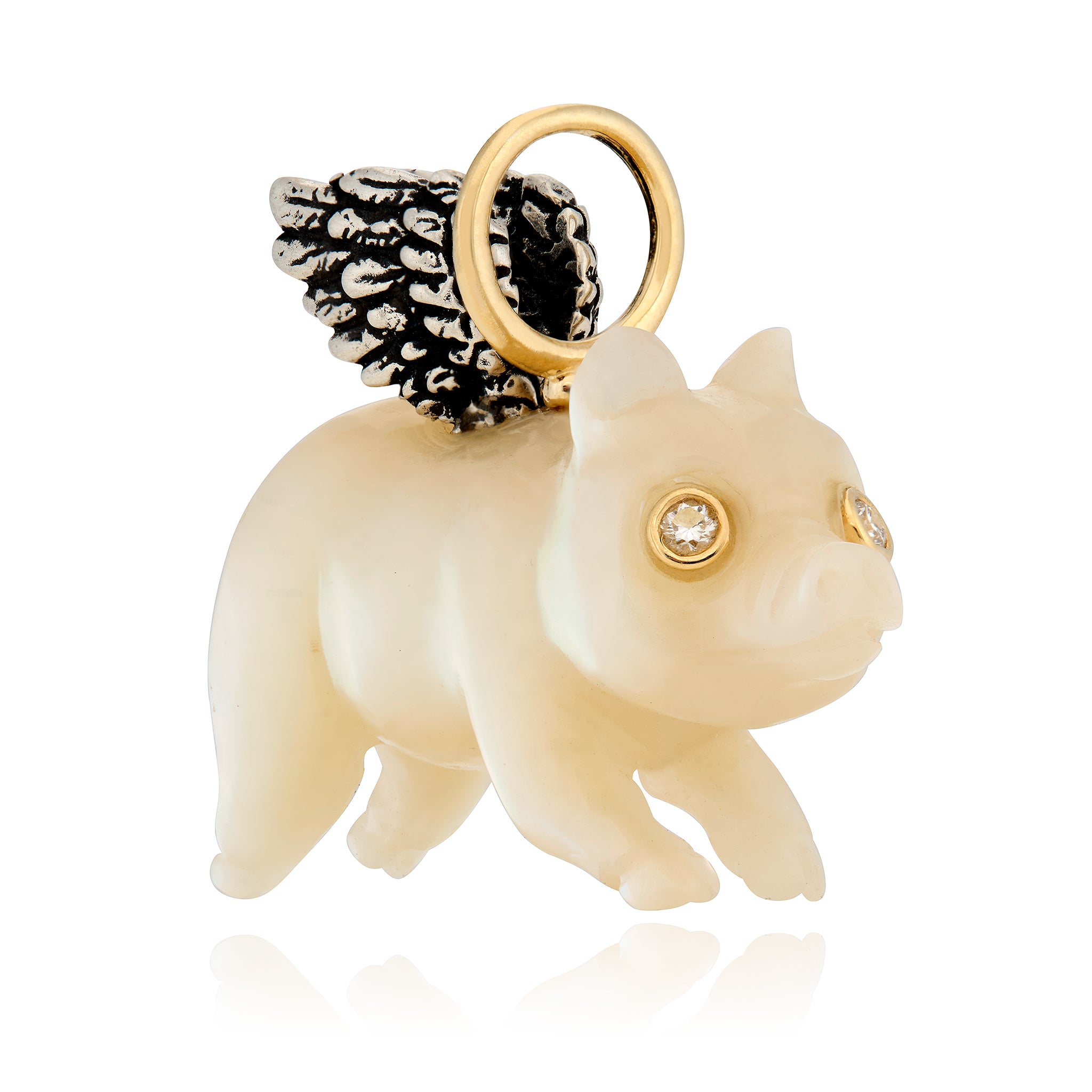 White mother of pearl lying pig charm with gold accents and diamond eyes on a white background