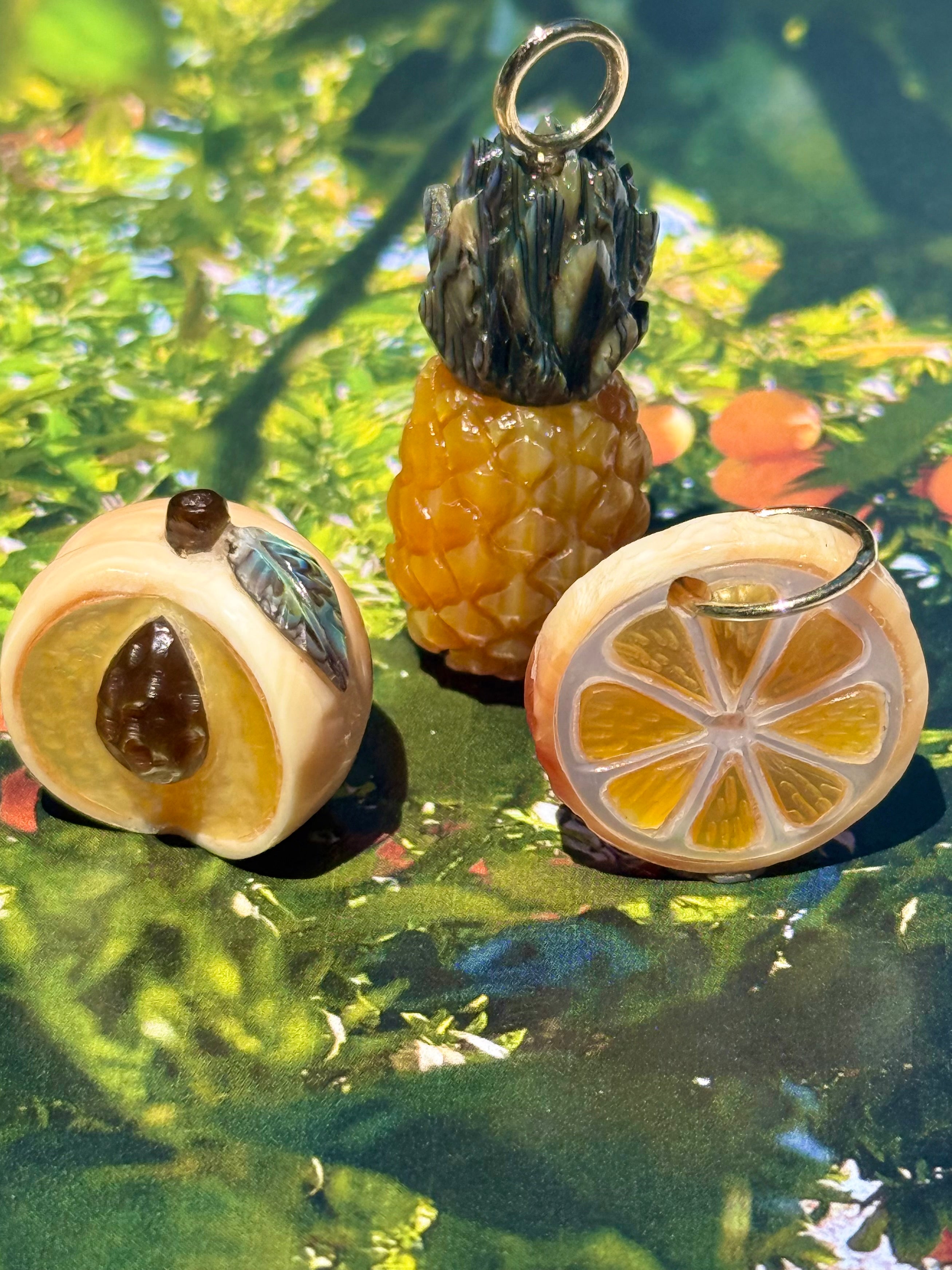 Peach, Pineapple, and orange slice charms on a green colorful background, designed by maura green