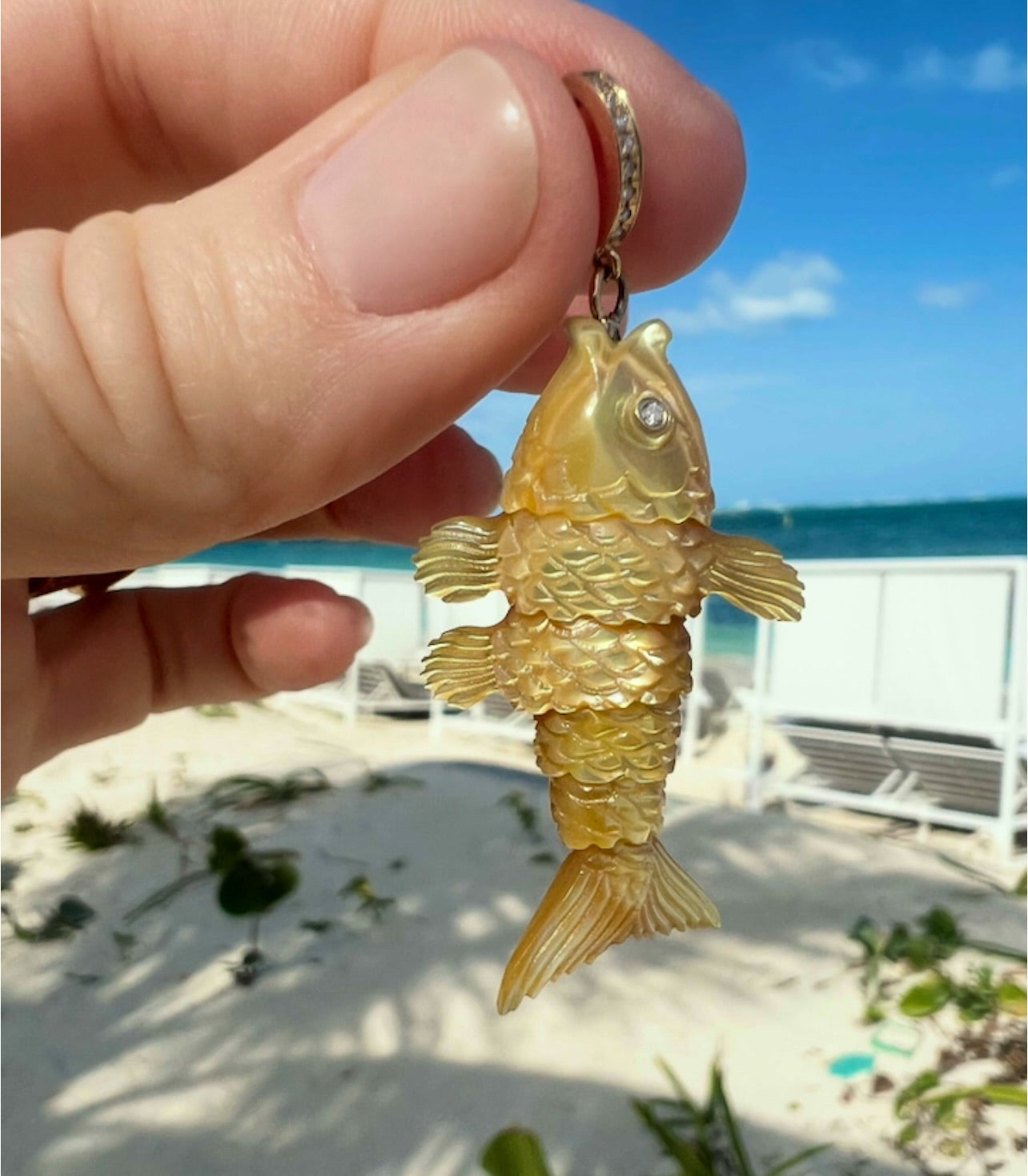 Gold fish-shaped charm designed by Maura Green