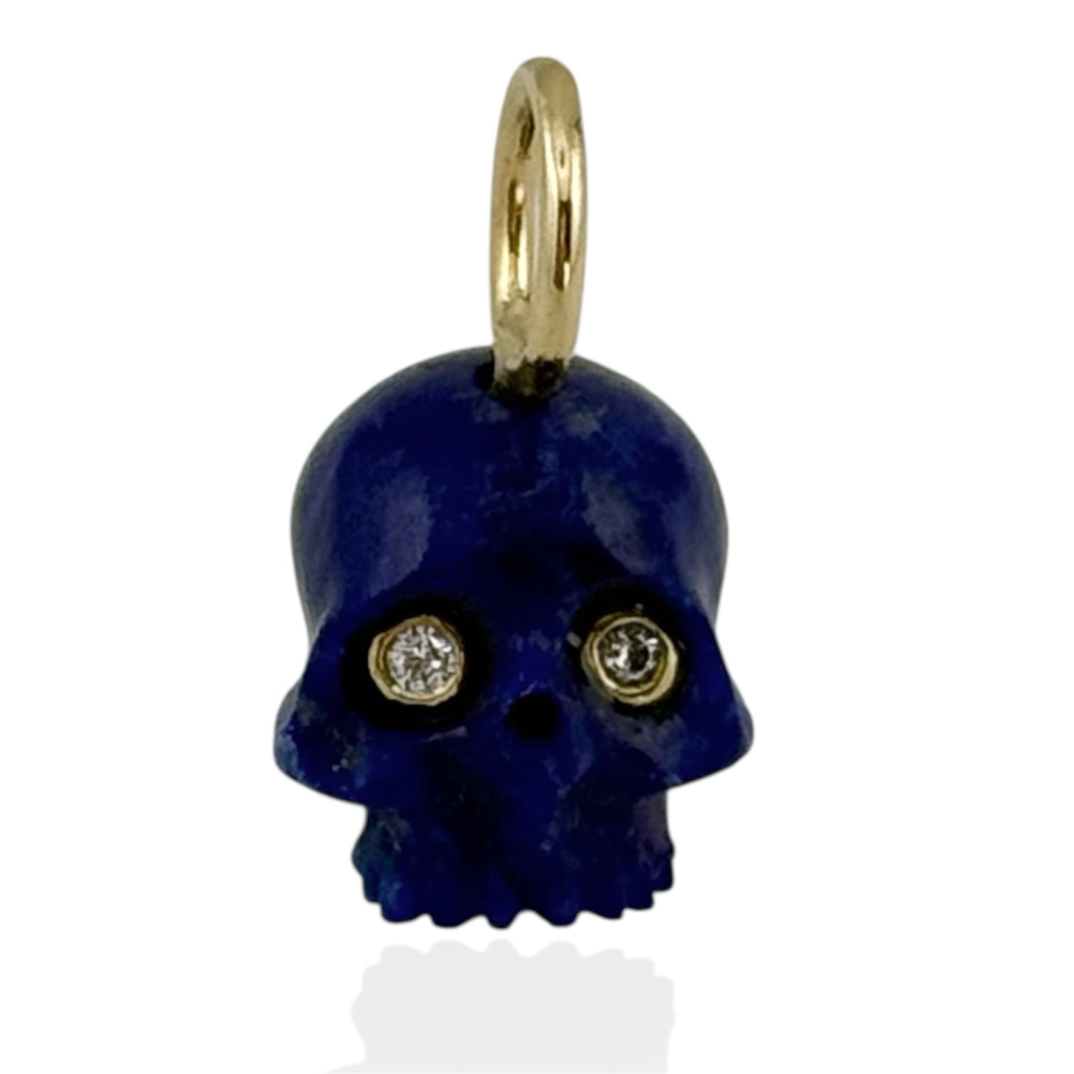 Blue lapis skull pendant with gold accents and diamond eyes on a white background