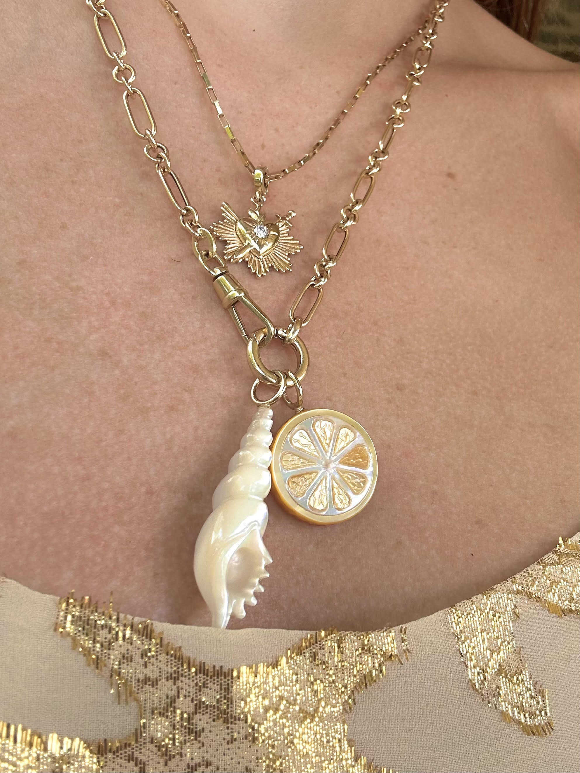Layered necklaces featuring a lemon slice charm. Designed by Maura Green