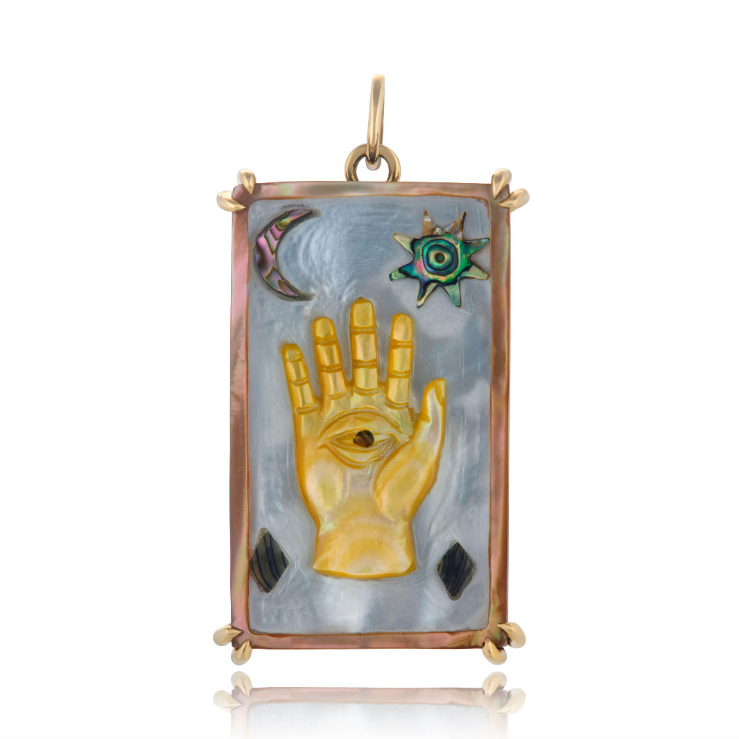 A 14K gold-colored Hamsa sacred symbol tablet with hand carved abalone and mother of pearl, featuring an evil eye symbol and other spiritual motifs.