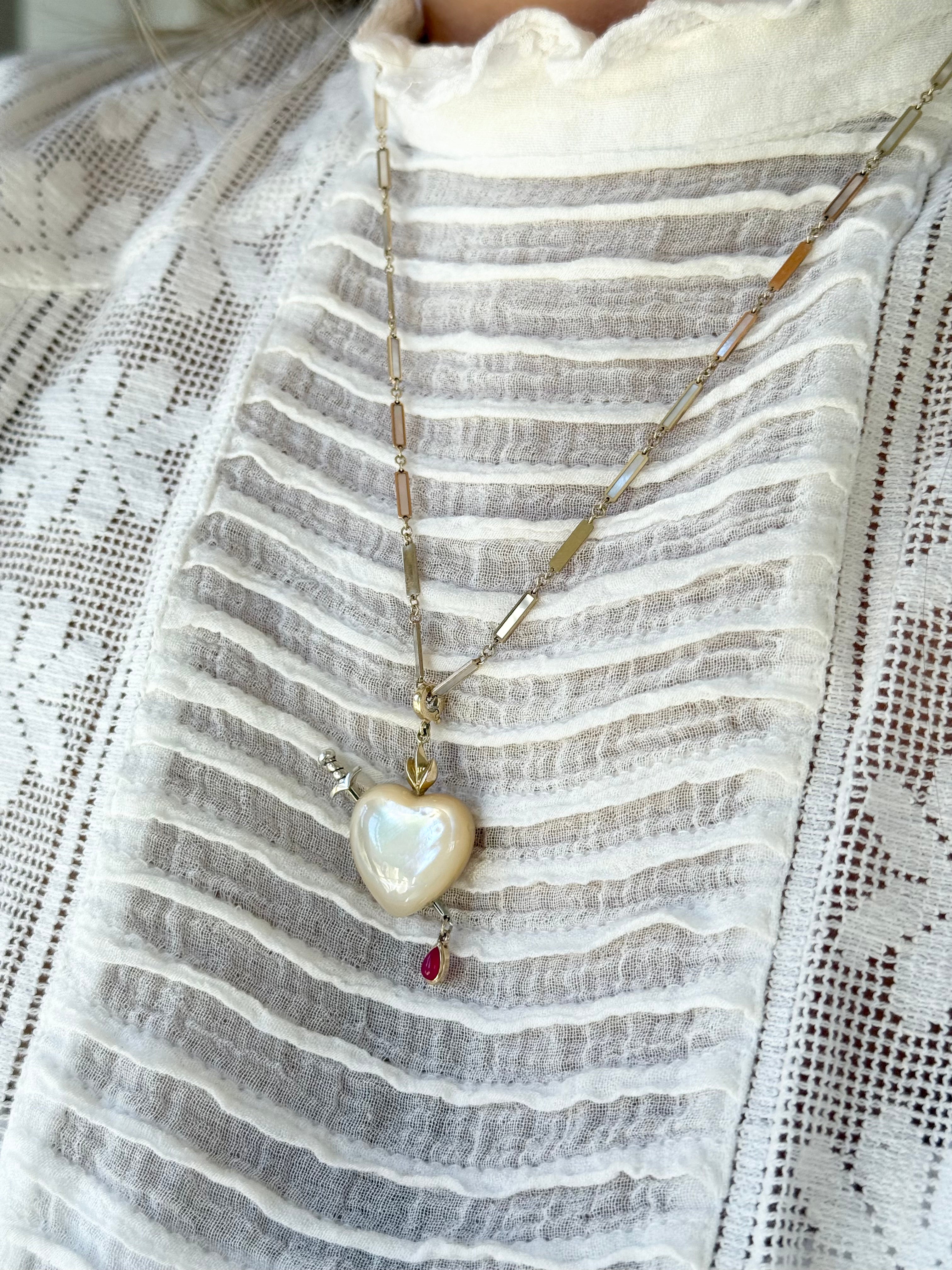 Maura Green Jewelry white mother of pearl sacred heart charm on a gold and mother of pearl chain.