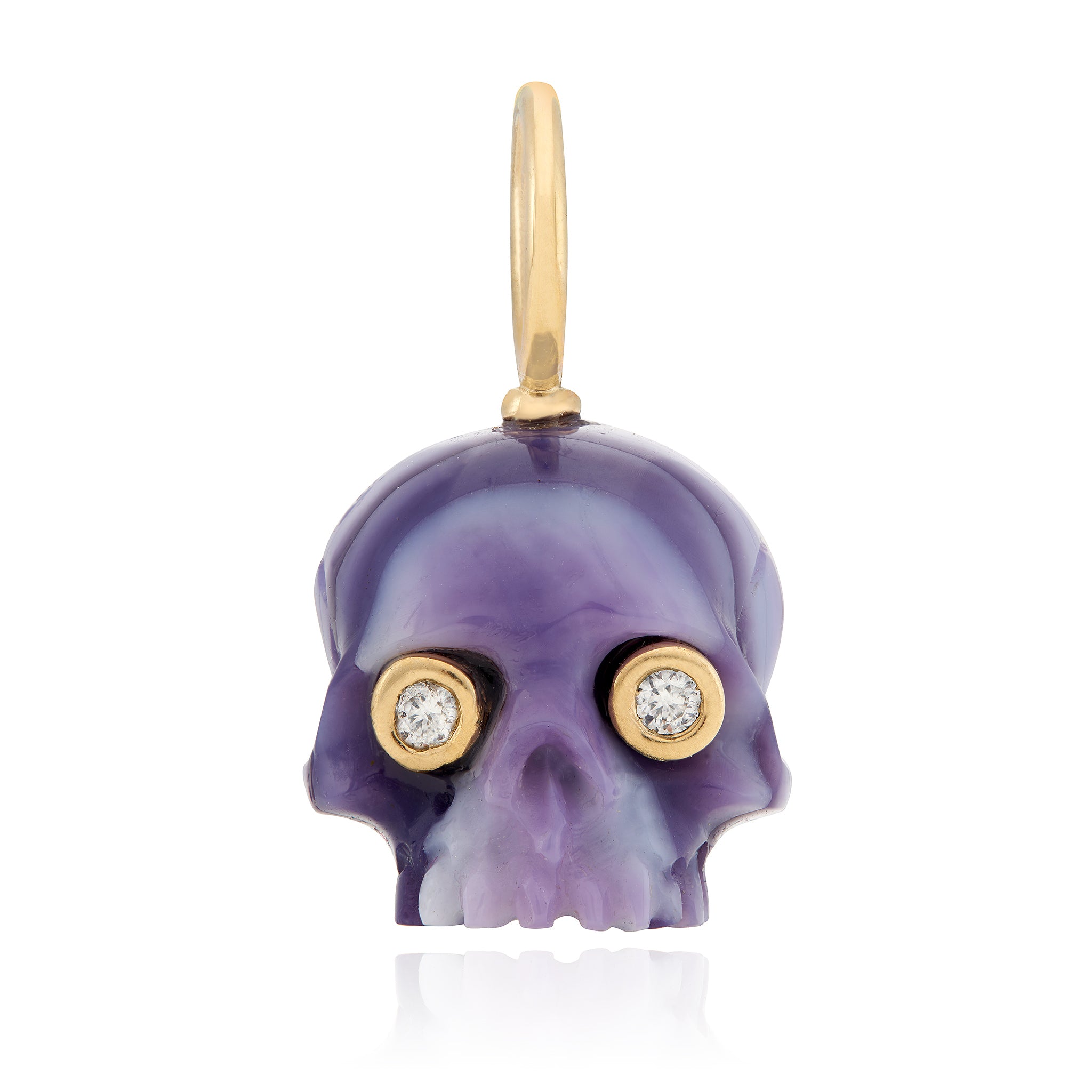 A purple clam shell skull charm with gold mounting and diamond eyes designed by Maura Green