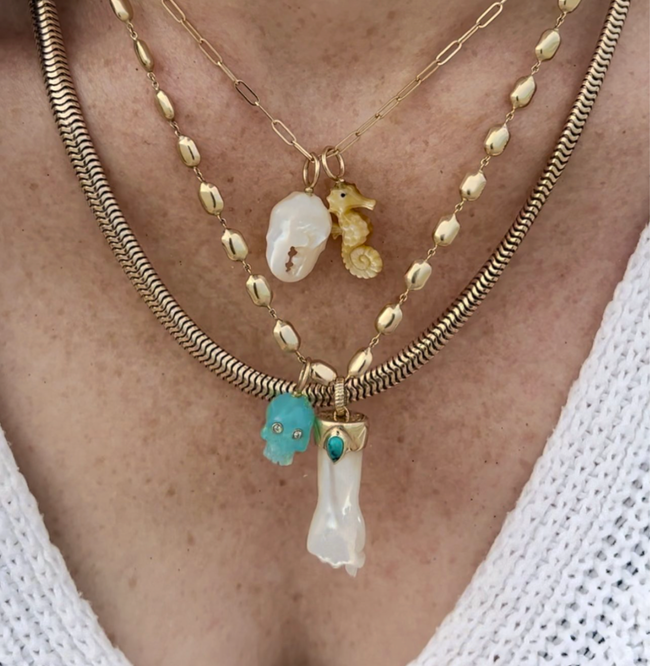 Layered necklaces featuring gold seahorse charm on a gold chain designed by Maura Green