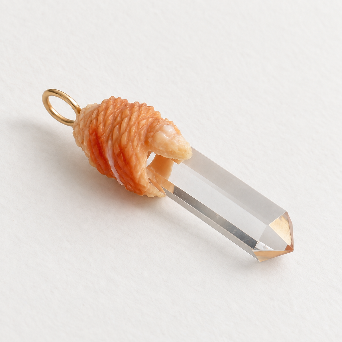 Hand-carved apricot conch shell wrapped around a clear chalcedony crystal point with a 14K yellow gold bail.