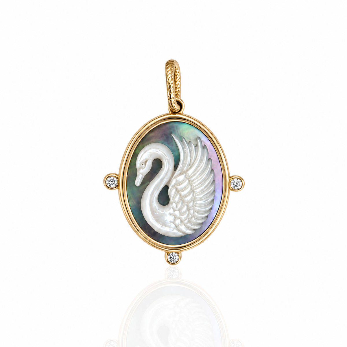 An oval charm pendant featuring a white carved swan on an iridescent mother-of-pearl background, set in a gold frame with small diamond accents, shown on a white reflective surface.