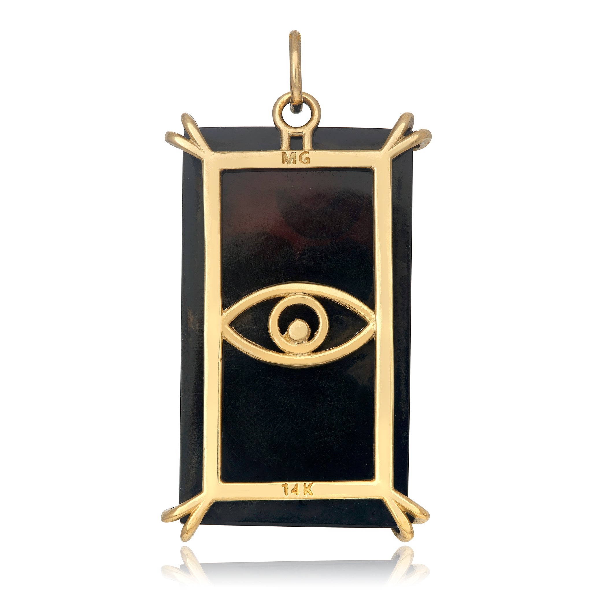 The back view of a dark, rectangular shaped charm in a gold setting with an evil eye design on the back.