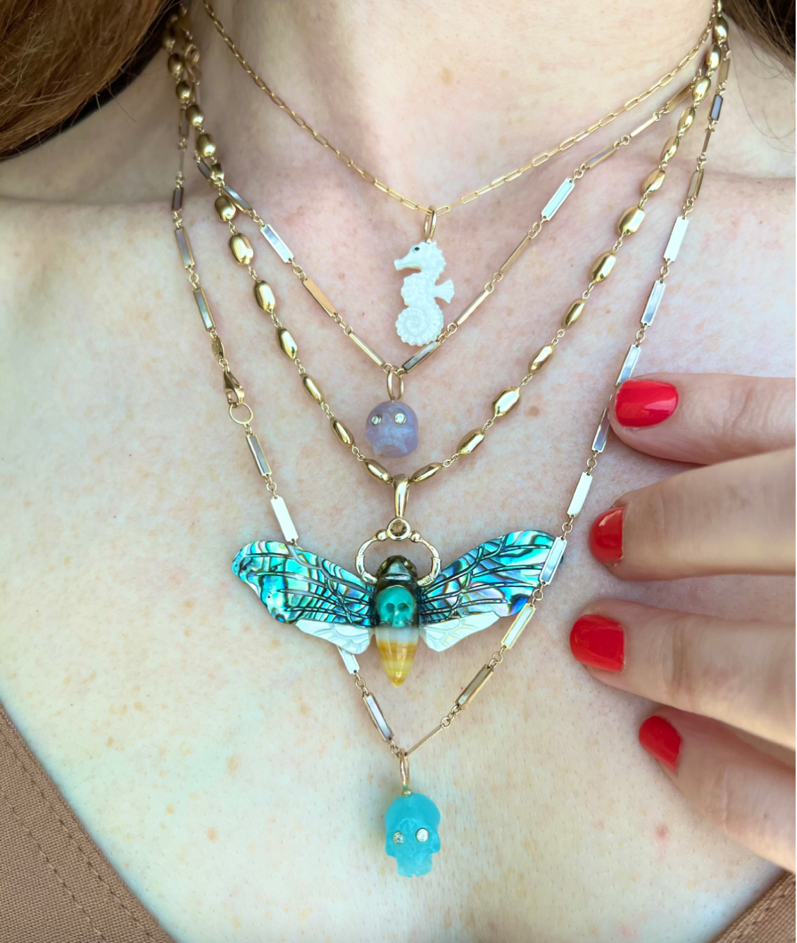 White mother of pearl seahorse charm with 14K gold designed by Maura Green