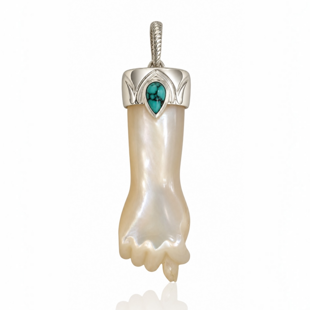 Hand-carved mother fo pearl mano figa charm with a sterling silver engraved cap, turquoise teardrop accent, and silver bail against a white reflective background. Designed by Maura Green.