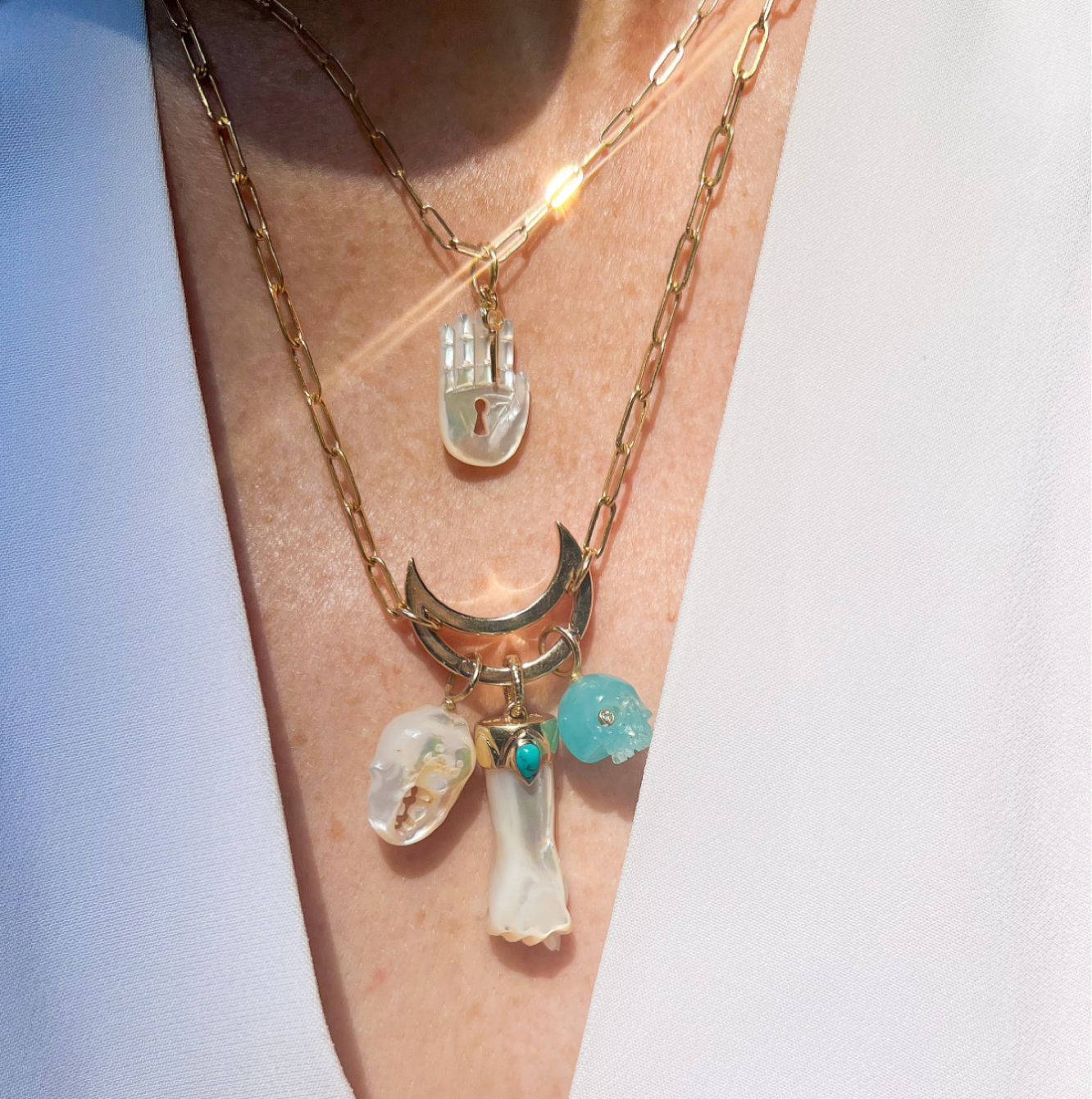 White mother of pearl seahorse charm with 14K gold worn on model designed by Maura Green