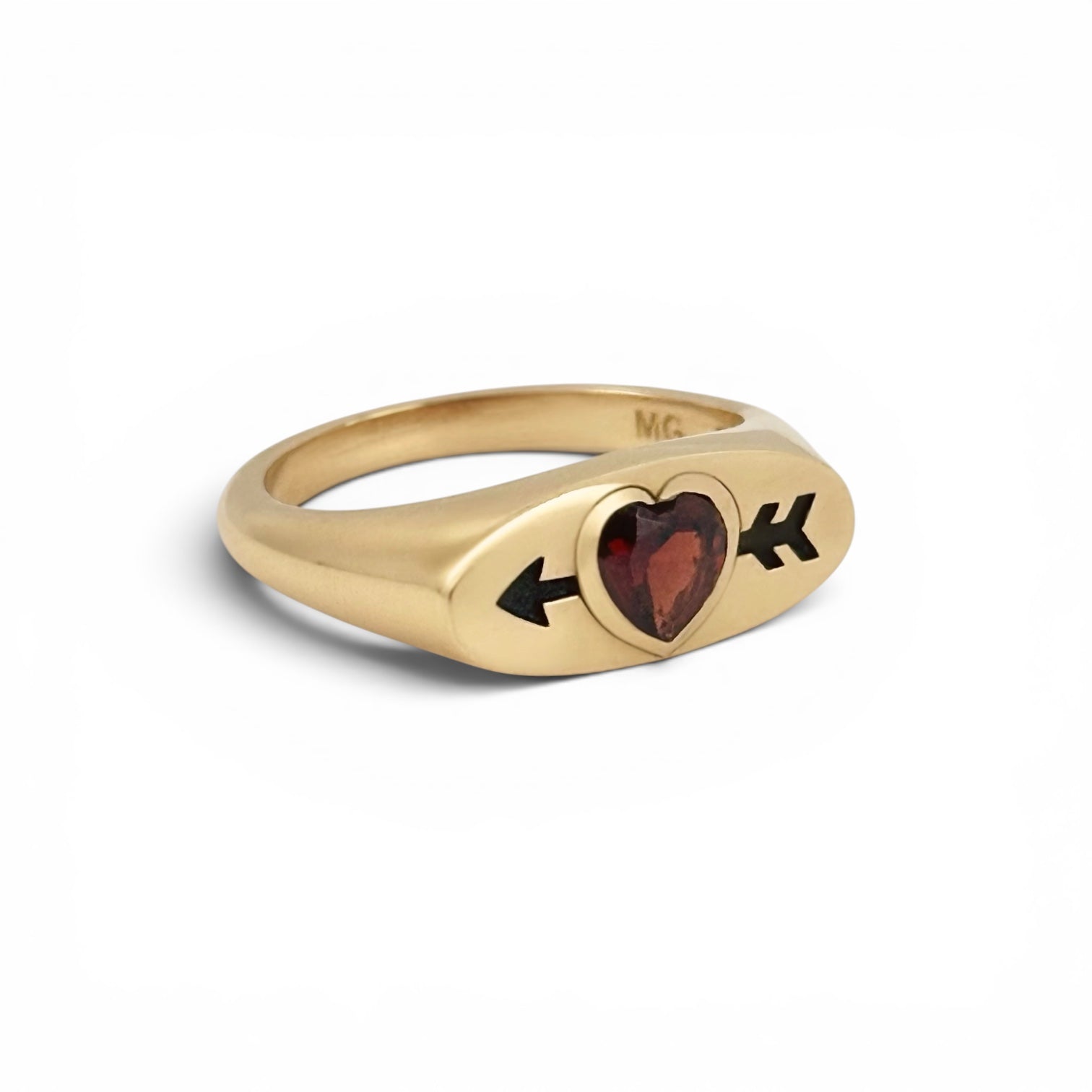 Gold ring with a red heart-shaped garnet with an arrow going through it. Designed my maura green