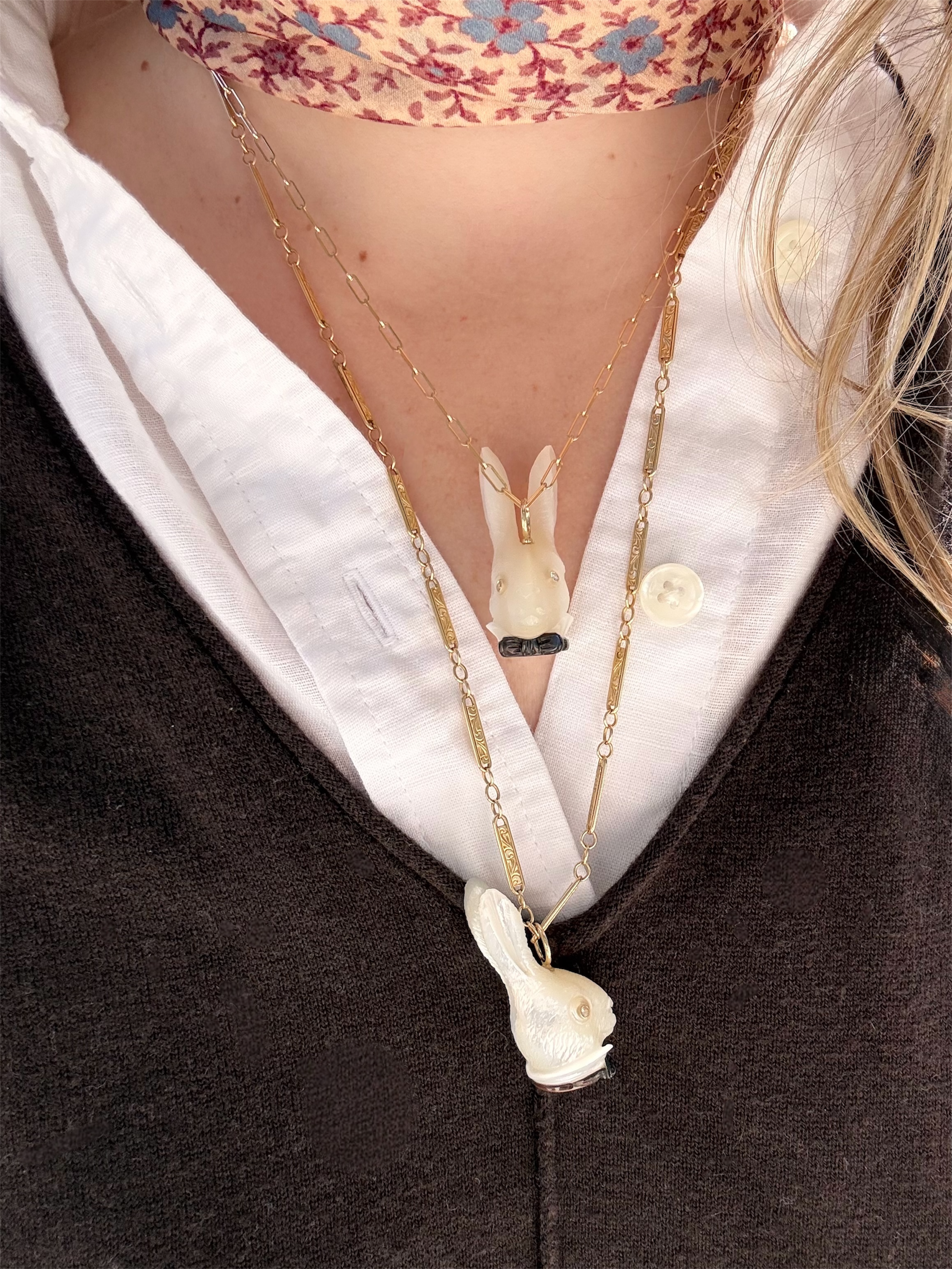 White rabbit head charms with a black bowtie and diamond eyes with a gold chain on a model. Designed by Maura Green