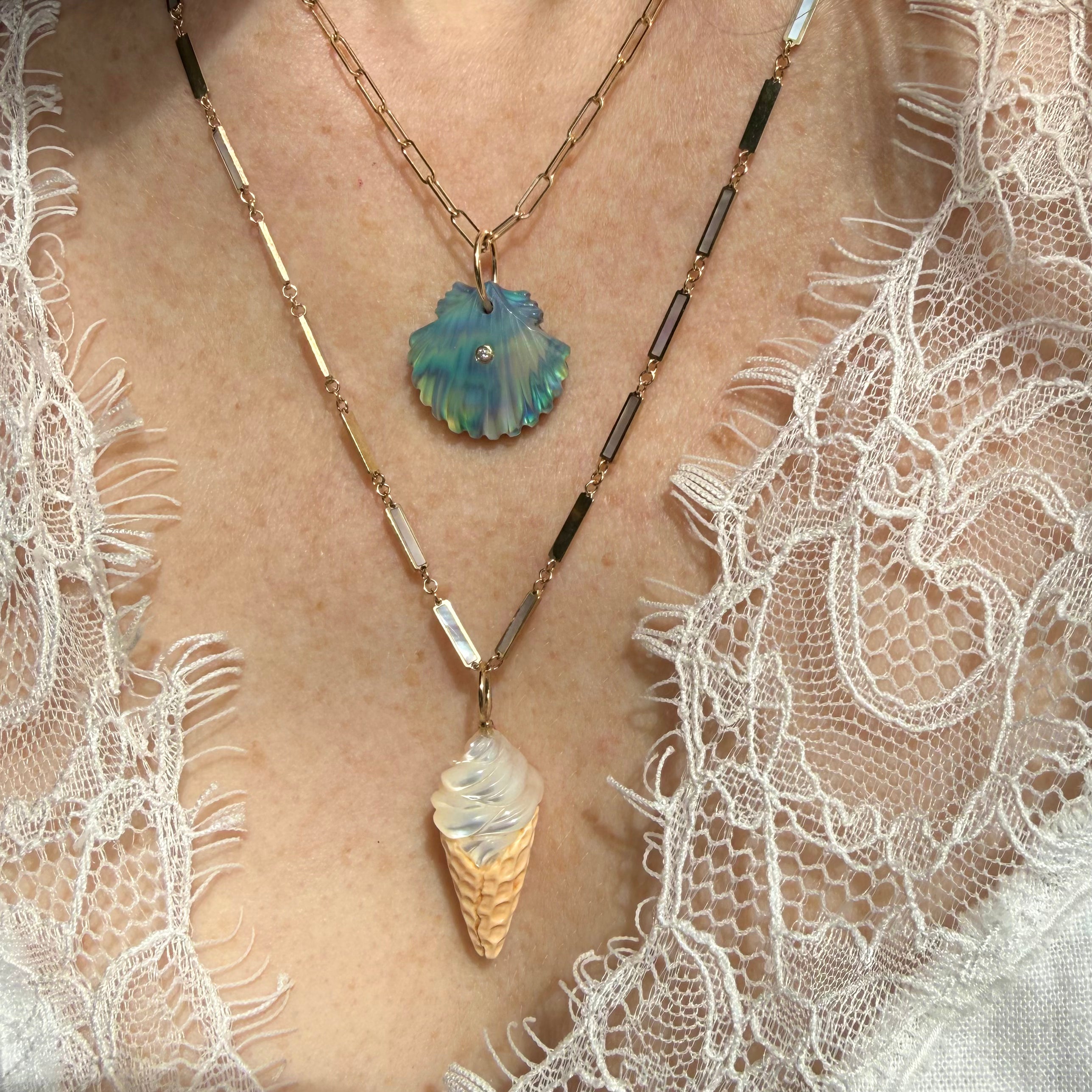 Ice cream cone charm layered with a gold chain on model's neck. Designed by Maura Green