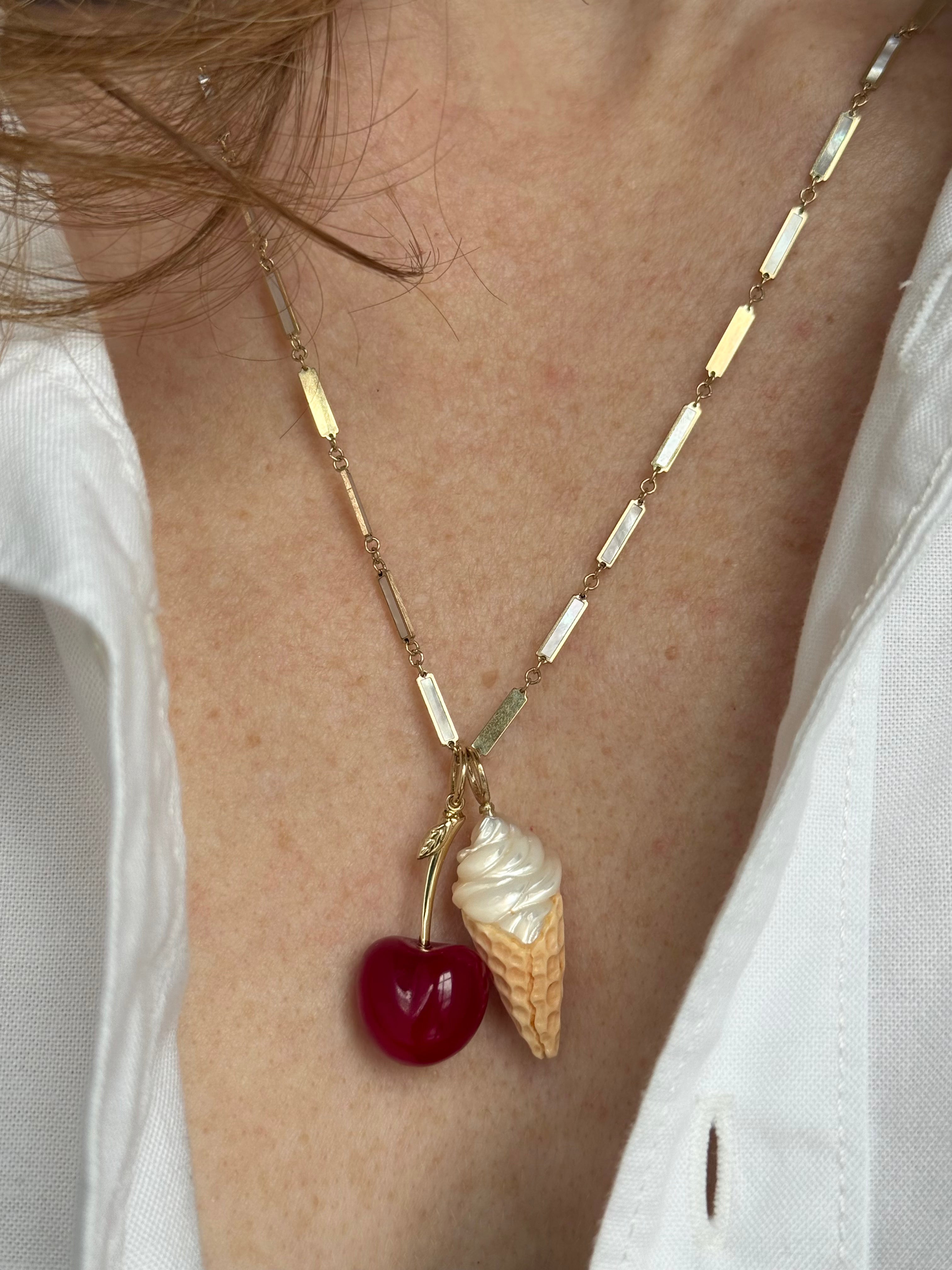 Necklace with cherry and ice cream cone pendant on a model. Designed by Maura Green