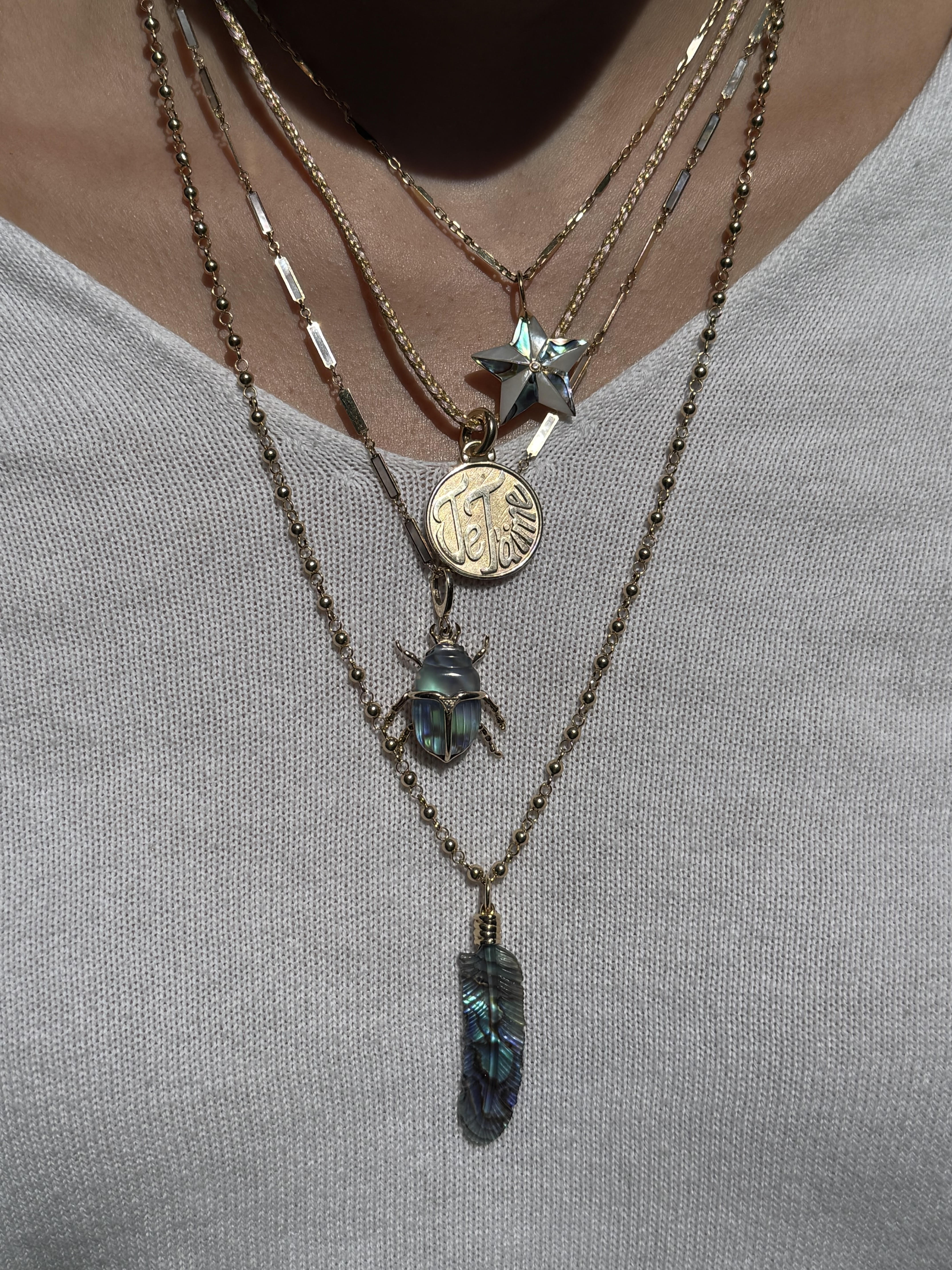 Necklace stack featuring Je T'aime charm on a pink and gold silk cord. Designed by Maura Green