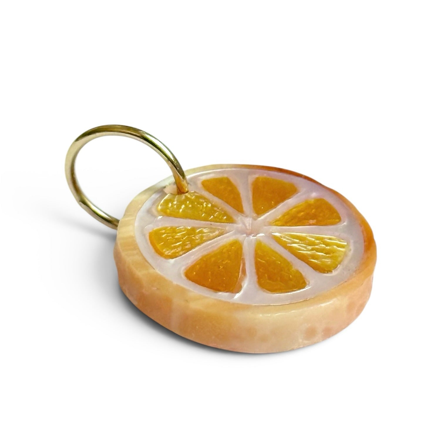 orange slice charm on a 14K gold bail with a white background designed by maura green