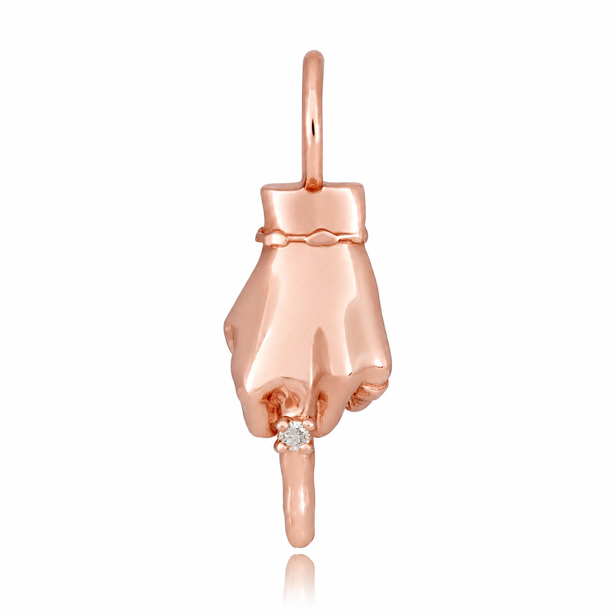 A rose gold figural hand charm wearing a diamond ring and making the middle finger gesture designed by Maura Green against a white background