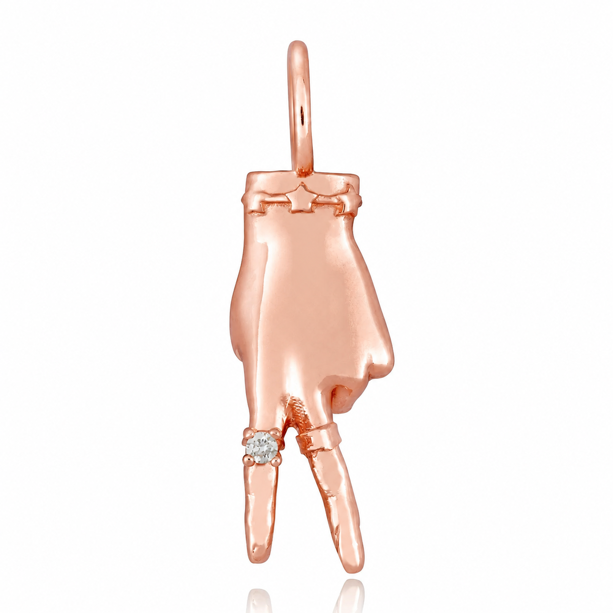 A rose gold charm in the shape of a hand making a peace sign gesture, with a small diamond ring on the finger designed by Maura Green against a white background.