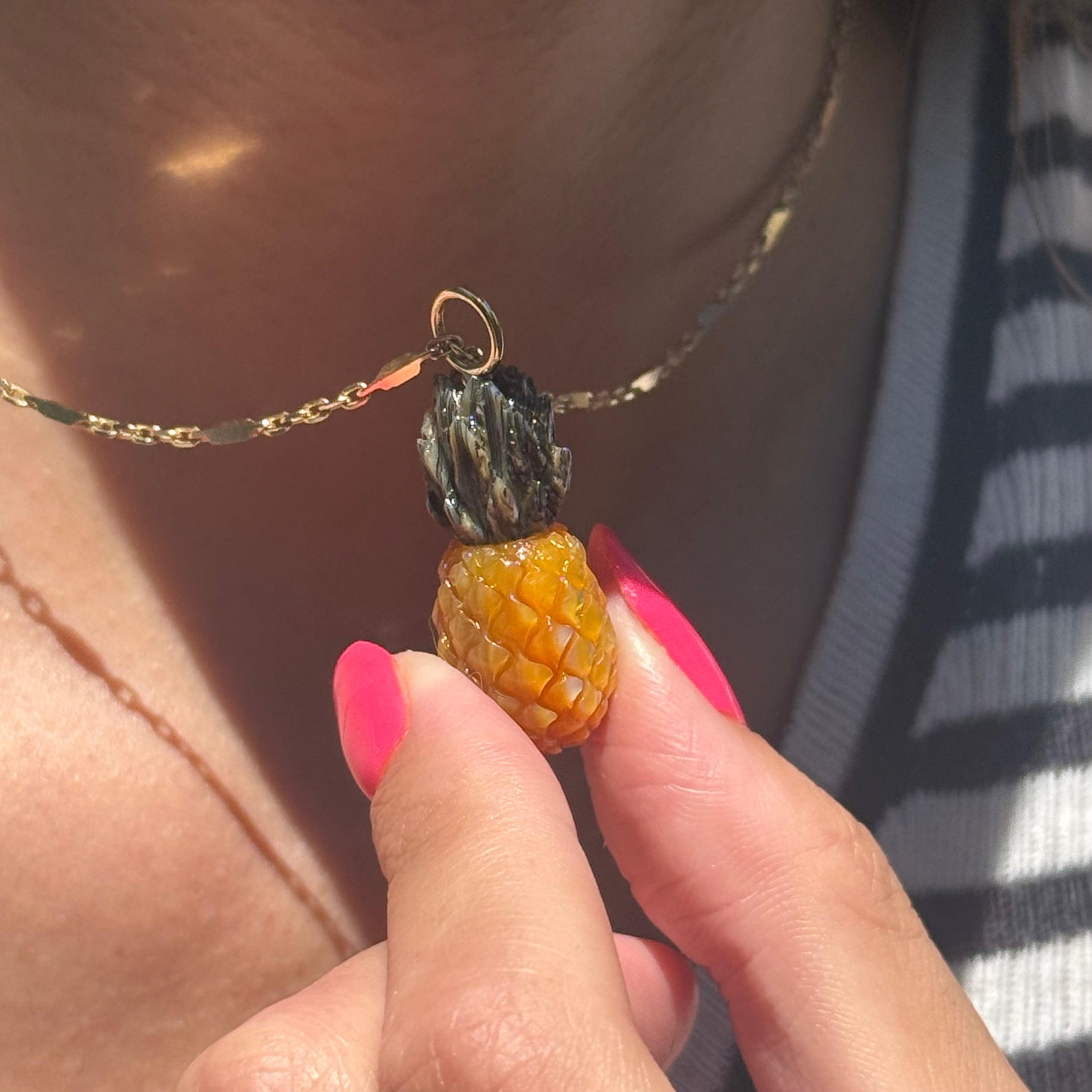 Pineapple Charm on a gold chain worn by model. Designed by maura green
