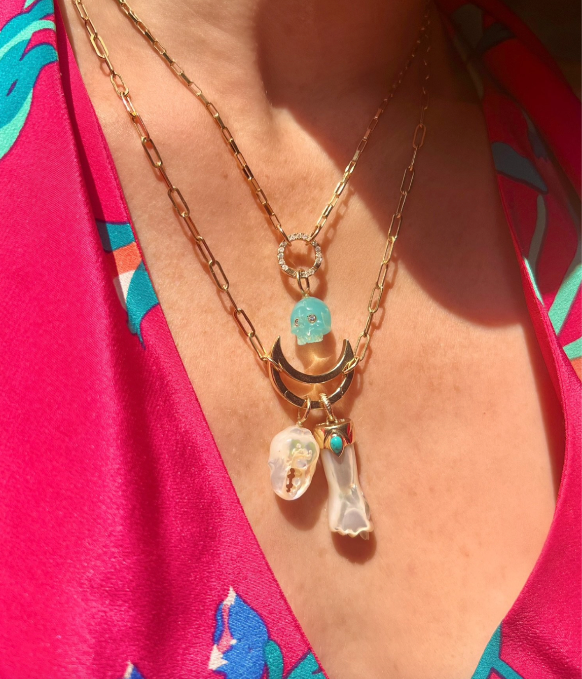White mother of pearl crab claw charm with 14K gold worn on model designed by Maura Green