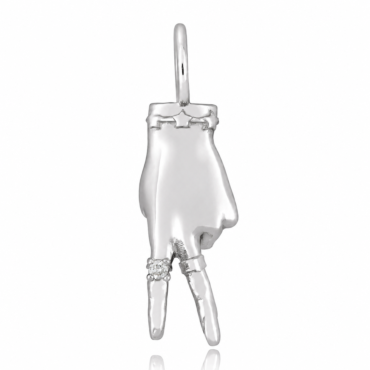 A white gold charm in the shape of a hand making a peace sign gesture, with a small diamond ring on the finger designed by Maura Green against a white background.
